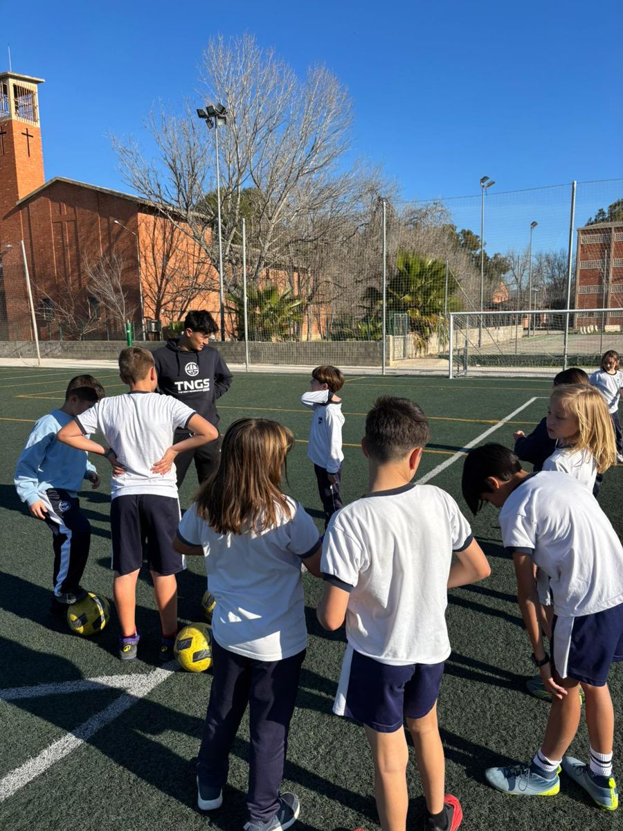 Alumno conduciendo el balón entre conos durante el entrenamiento