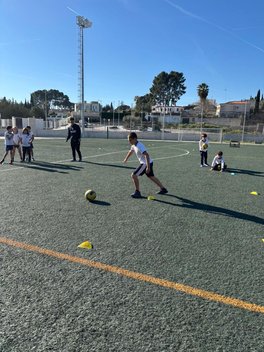 Alumnos atendiendo la explicación del entrenador en el campo